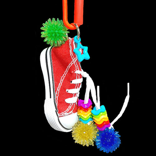 A miniature canvas sneaker decorated with brightly colored wiggle rings, mini spike balls and a charm. Makes a great foraging toy - simply hide a treat or two inside for foraging fun! Note: Sneaker does not have metal grommets like some do! Comes in assorted colors.  Hangs approx 6