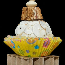 Load image into Gallery viewer, Two super soft sola balls nestled inside colorful paper cupcake liners with a cardboard honeycomb block in the middle and mahogany chunks on both ends. Strung on stainless steel wire with small wood beads and pony beads.