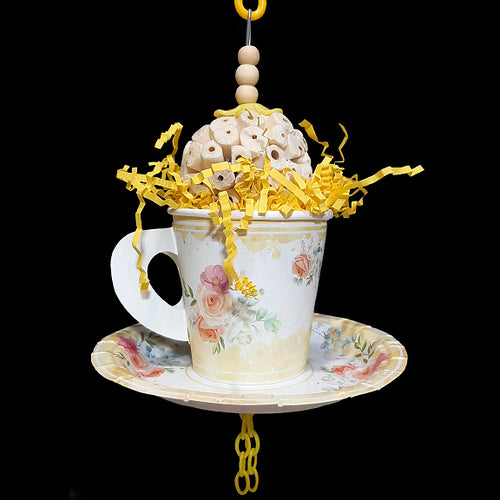 Your bird is sure to have a party with this super-soft sola ball nestled inside a paper tea cup and saucer! The cup is stuffed with crinkle paper shred and has a cork stopper hidden inside. Strung on stainless steel wire with small wood snap beads and plastic chain. Designed for small to intermediate sized birds.  Measures approx 3