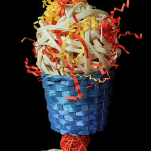 Load image into Gallery viewer, Foraging conure bird toy made with a giant bamboo ball filled with crinkle paper nestled inside a brightly colored woven bamboo basket with corn husk braids and mini vine balls trailing underneath. Strung on paper rope. 
