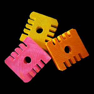 Brightly colored pine slices measuring approx 1-5/8" by 1-1/2" by 3/8" thick with a 3/8" center hole. The slices have grooves in the sides for easy chipping.